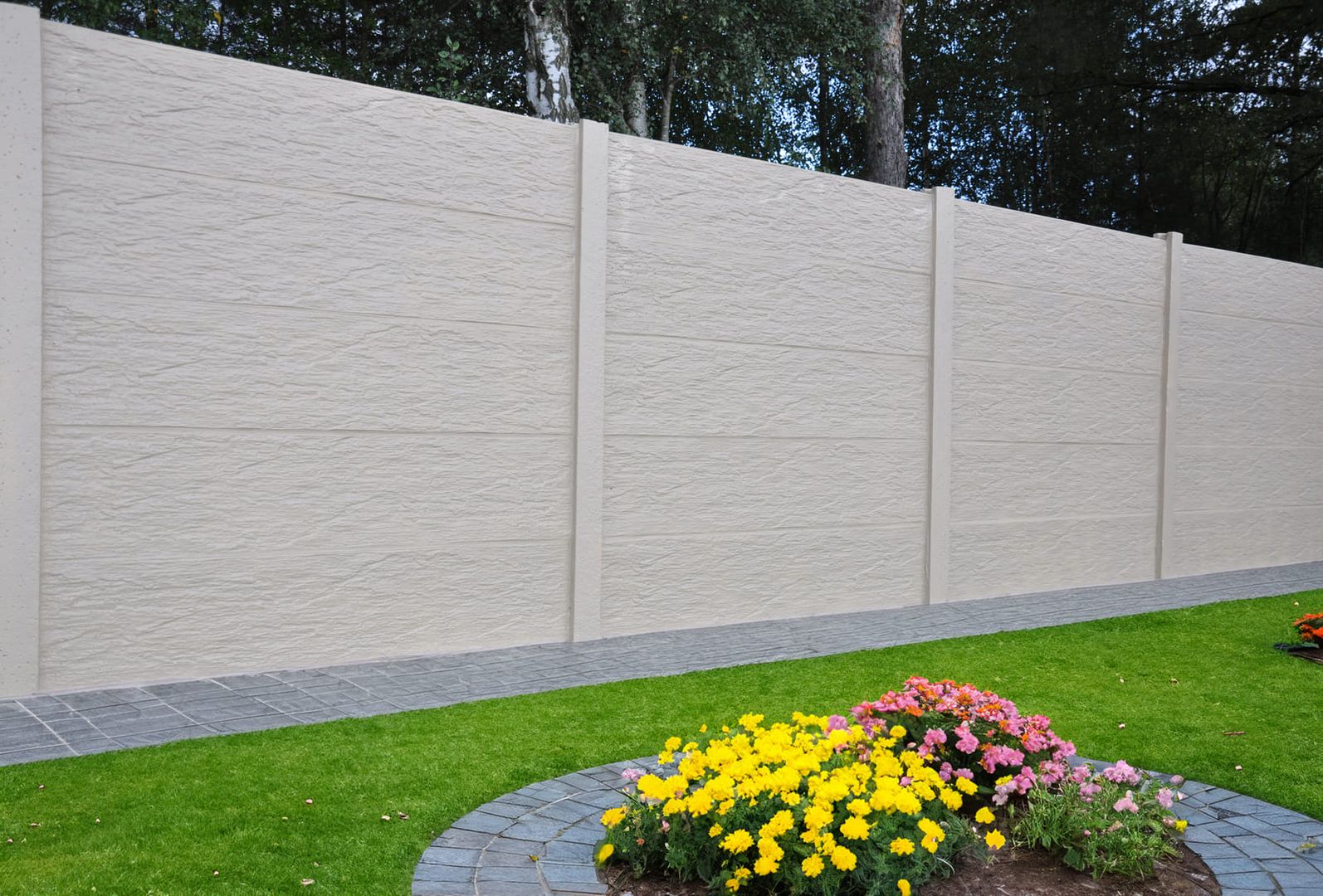 Schiefer Naturell Betonzaun mit Blumen und Rasen