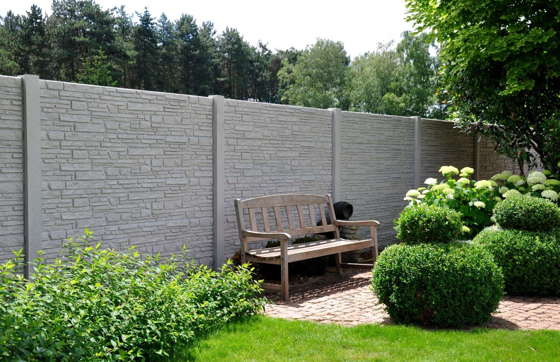 Ein Betonzaun mit Flechtmuster und einer Sitzbank